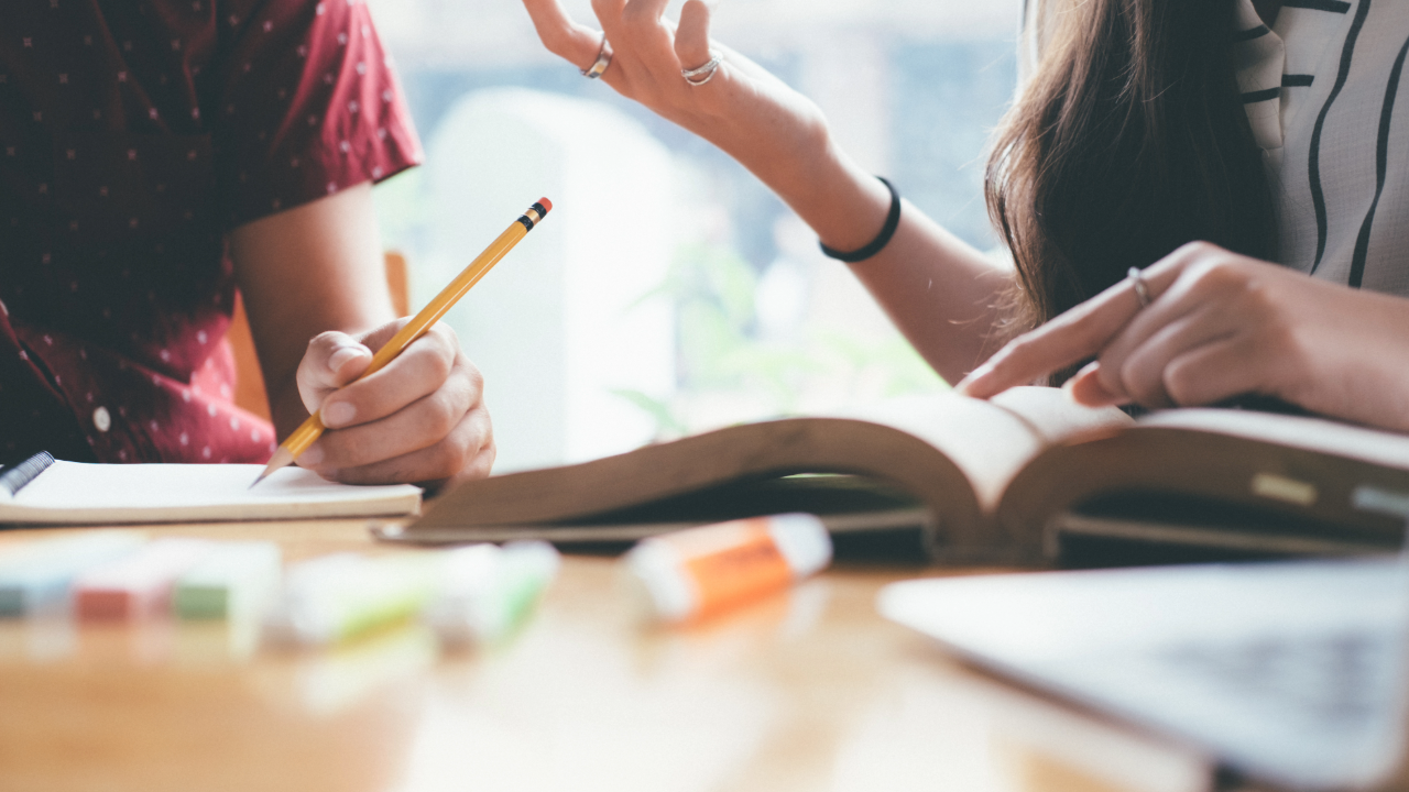Wenn Wissen greifen soll: Warum Print der Bildung neuen Fokus gibt aufgeschlagenes Buch mit händischen Gesten