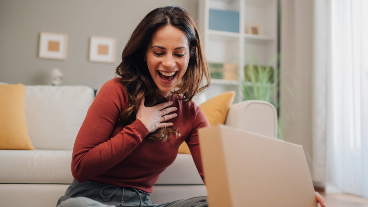 Frau überrascht nach Öffnen eines Pakets